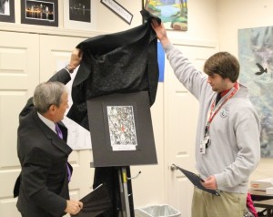 Congressman John Yarmuth and senior Ben Kline unveil Kline's winning photo. 