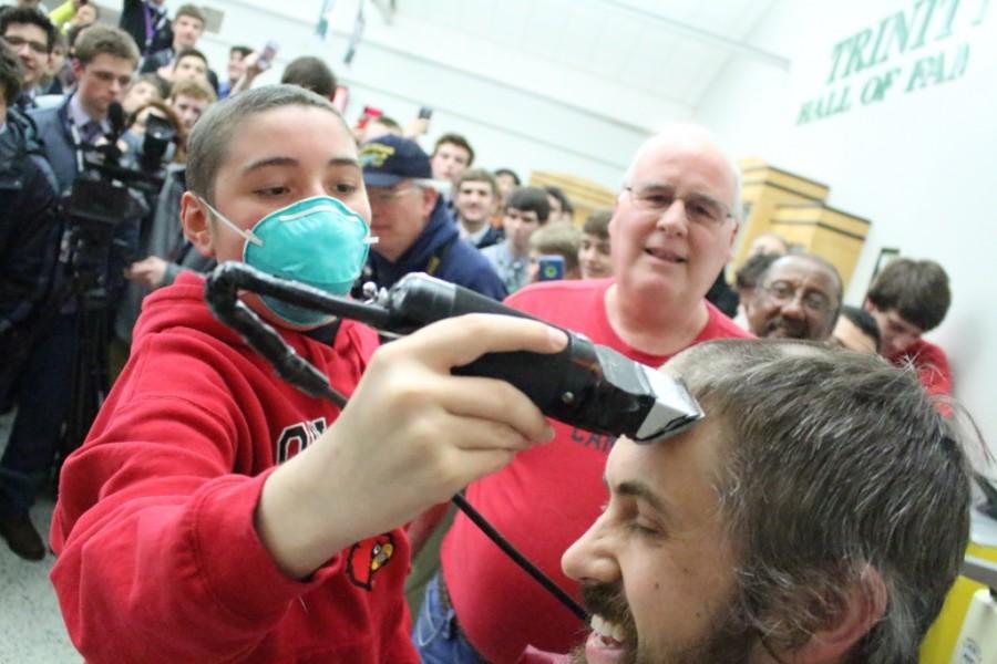 Trinity sophomore Owen McMasters, who is battling blood cancer, helped shave Mr. Mark Amicks head as part of fundraising for the St. Baldricks Foundation, an organization that fights childhood cancer. 