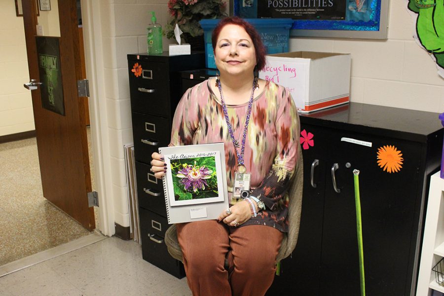 Ms. Debbie Walling, former moderator for The Axiom, holds a copy of last year's literary magazine. 