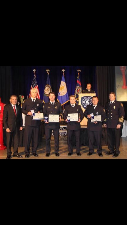 Trinity 2012 alumnus  Daniel Hogg, a firefighter standing second from the right next to Chief Greg Frederick, was honored for valor.