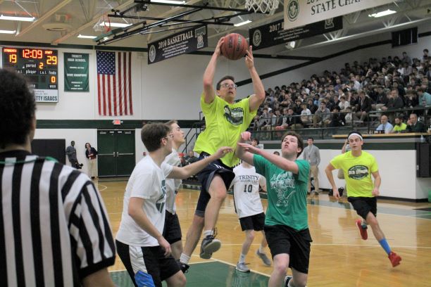 Trinity+teacher+Mr.+Josh+Kusch+drives+to+the+basket+during+the+2019+annual+Student-Faculty+Basketball+Game.